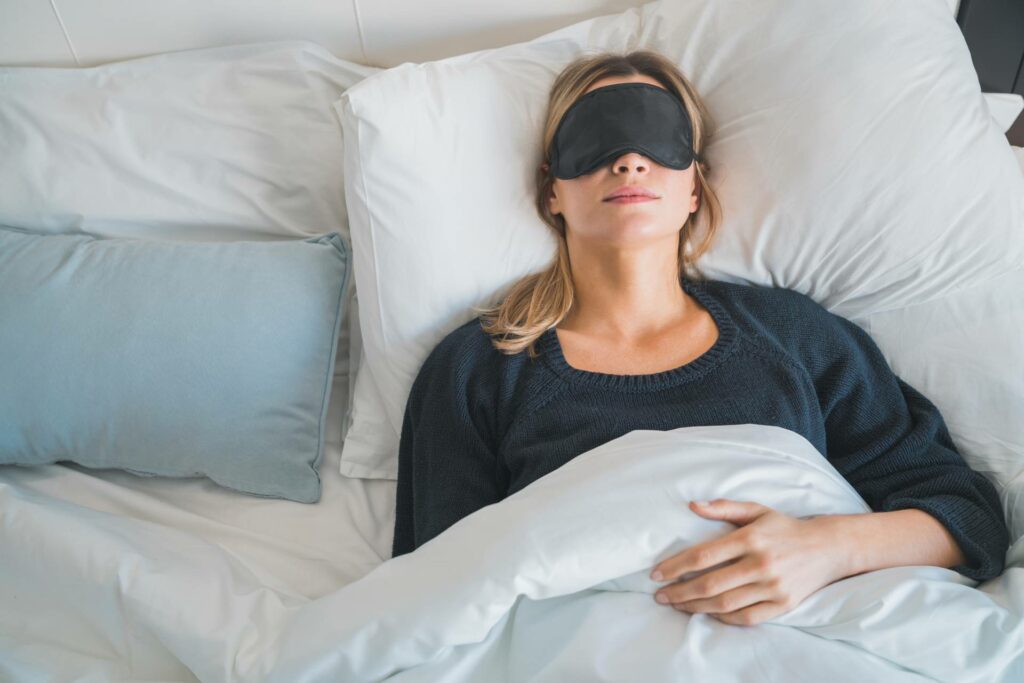 donna distesa con una maschera per dormire