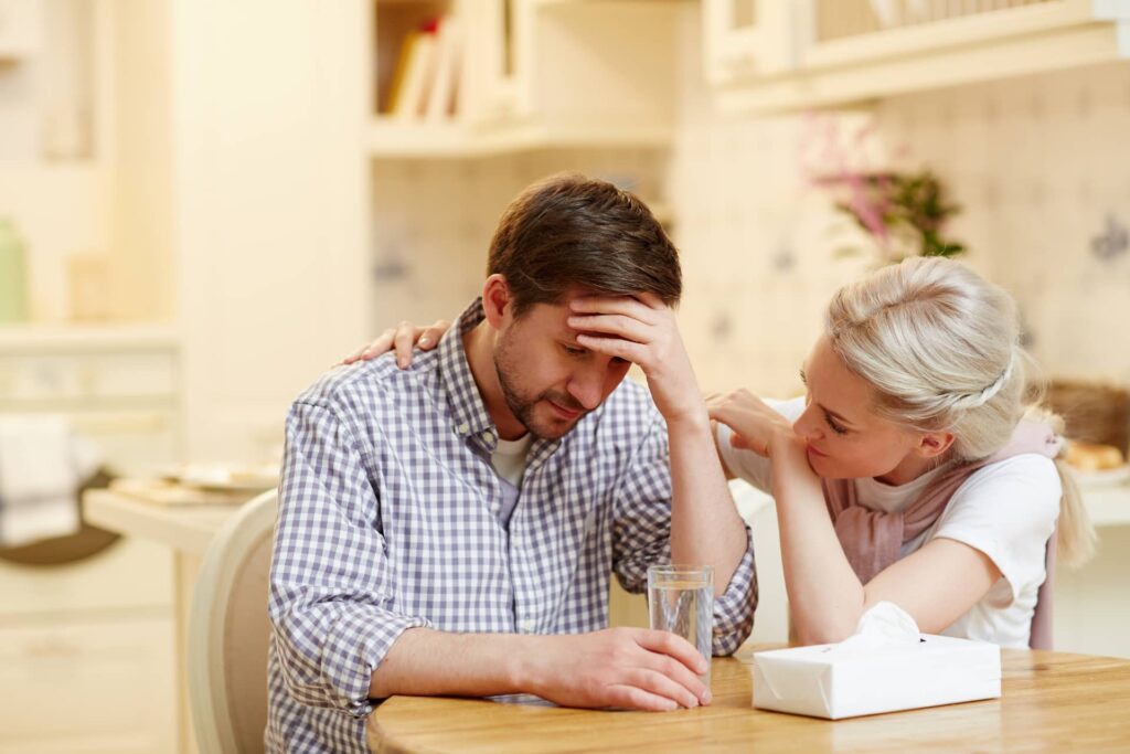uomo e donna seduti a un tavolo preoccupati per i problemi di coppia
