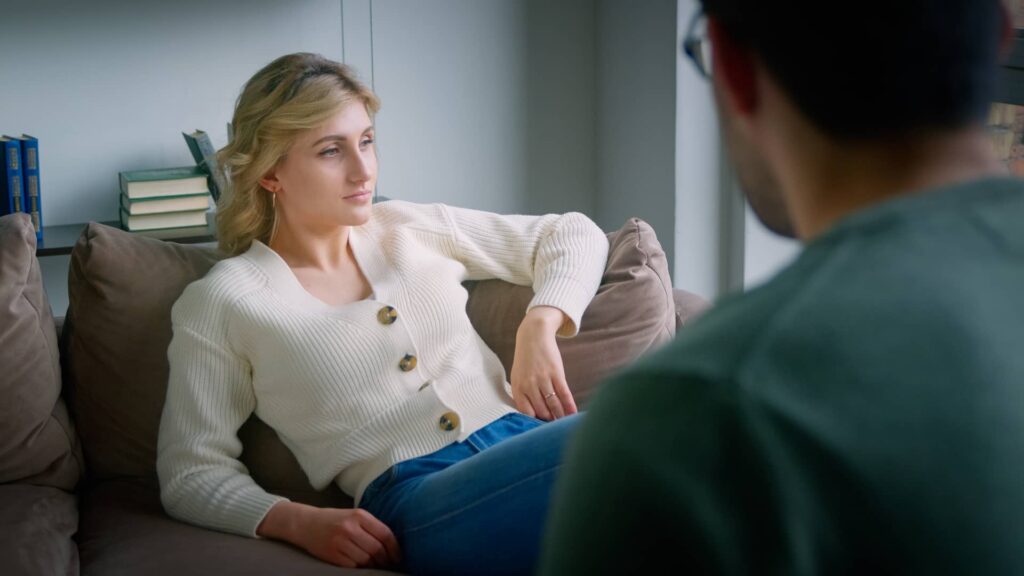 Ragazza bionda seduta sul divano che cerca una soluzione ai suoi problemi di ansia