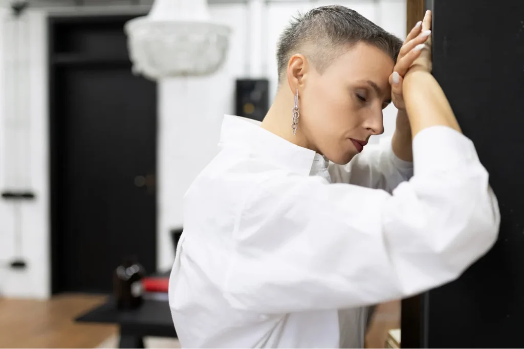 Donna che appoggia la testa alla mani in segno di preoccupazione