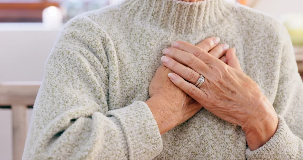 Dettaglio di mani di donna anziana che si stringono al petto