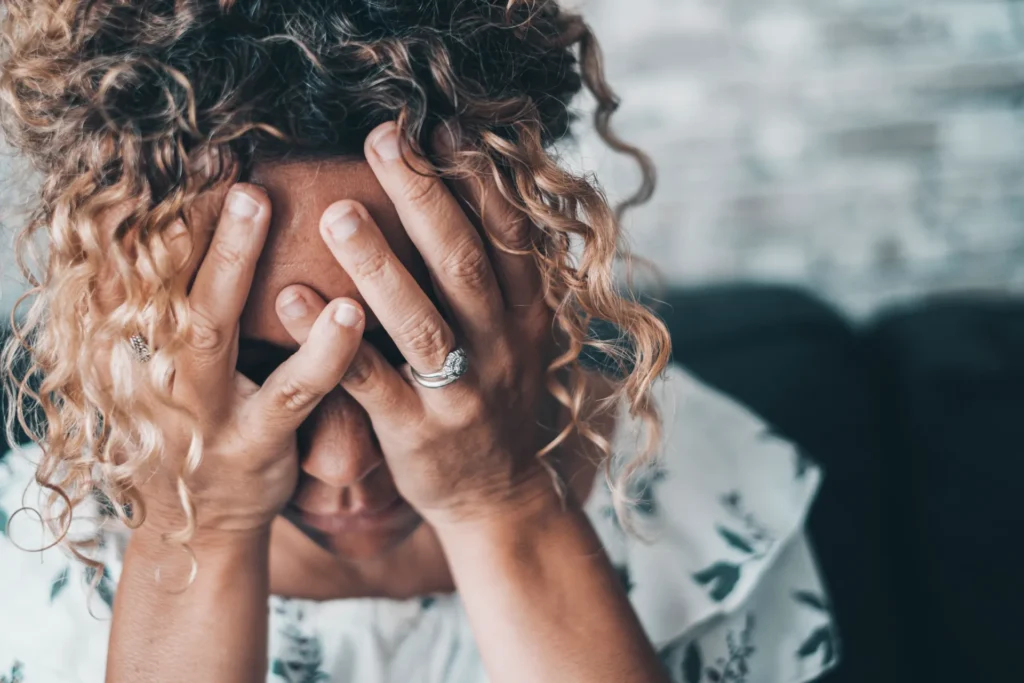 Donna disperata si tiene il viso tra le mani per il troppo stress