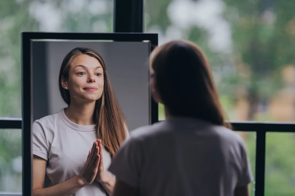 Giovane donna allo specchio che si guarda motivata
