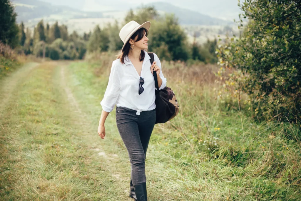 Giovane donna sorridente che passeggia in un bosco
